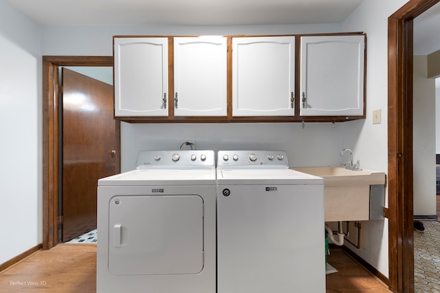 laundry area featuring hardwood / wood-style flooring, cabinets, and independent washer and dryer