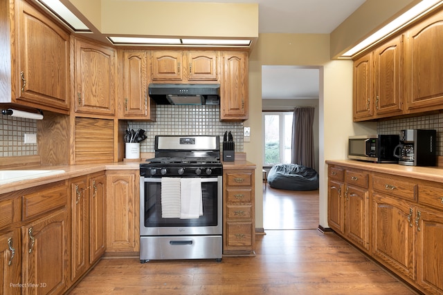 kitchen featuring stainless steel appliances, tasteful backsplash, and light hardwood / wood-style floors