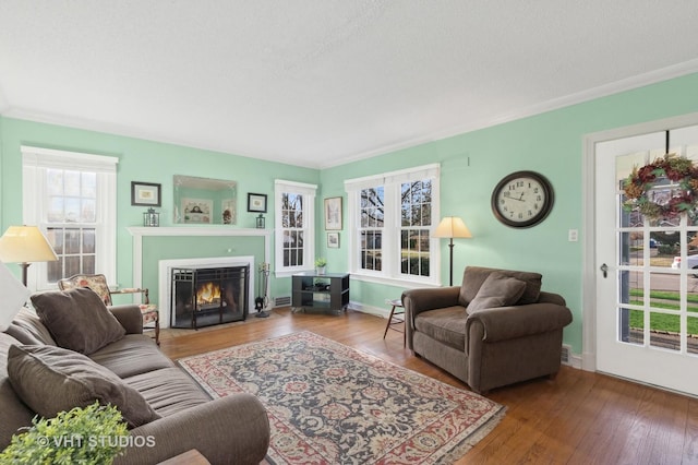 living room featuring a textured ceiling, wood-type flooring, and crown molding