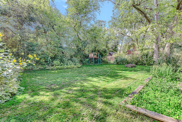 view of yard with a playground and an outdoor fire pit