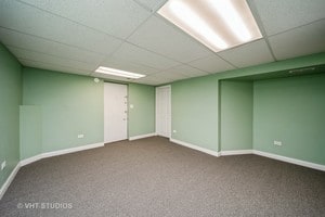 basement featuring a drop ceiling and carpet