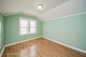 additional living space featuring hardwood / wood-style floors and vaulted ceiling