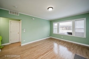 spare room featuring light hardwood / wood-style flooring and ornamental molding