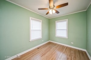 empty room featuring hardwood / wood-style floors, ceiling fan, and crown molding