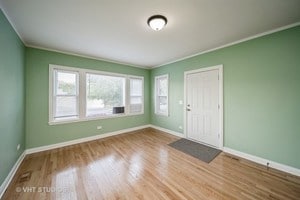 spare room with wood-type flooring and ornamental molding