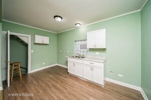 kitchen featuring white cabinets, hardwood / wood-style floors, ornamental molding, and sink