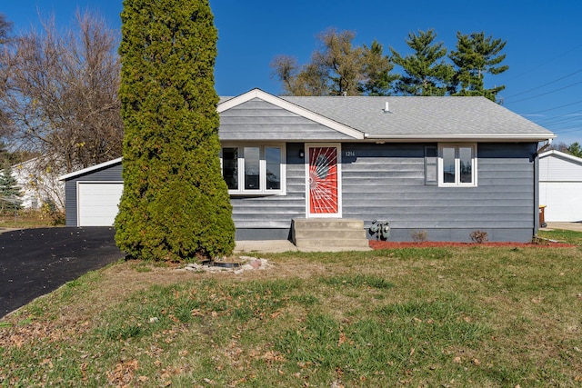 view of front of property featuring an outbuilding, a front yard, and a garage