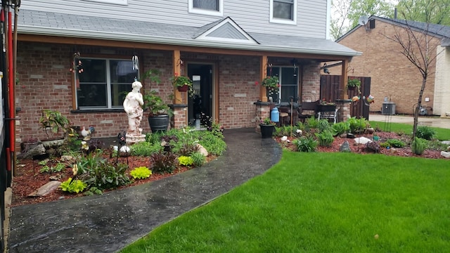 view of front of home with cooling unit and a front lawn