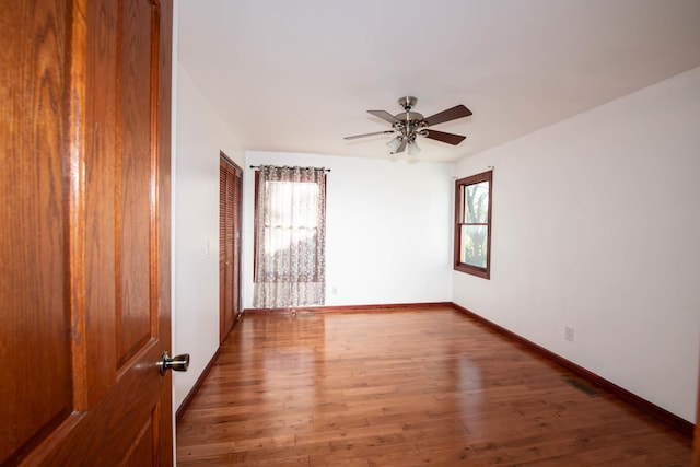 unfurnished room with hardwood / wood-style floors, ceiling fan, and a healthy amount of sunlight