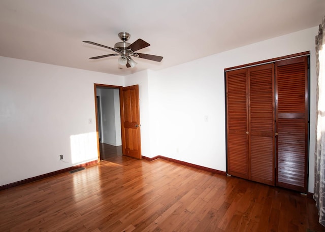 unfurnished bedroom featuring ceiling fan, a closet, dark hardwood / wood-style floors, and radiator heating unit