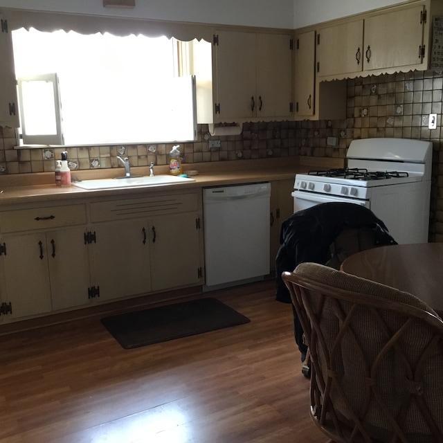 kitchen with white appliances, light hardwood / wood-style floors, backsplash, and sink