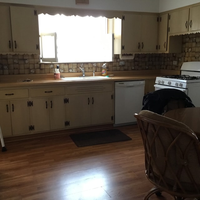 kitchen with decorative backsplash, white appliances, dark wood-type flooring, sink, and white cabinetry