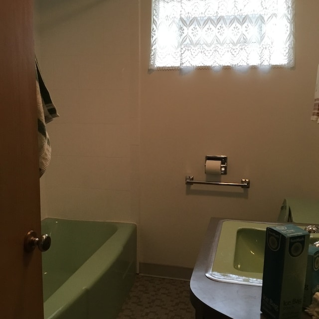 bathroom with a tub to relax in and vanity