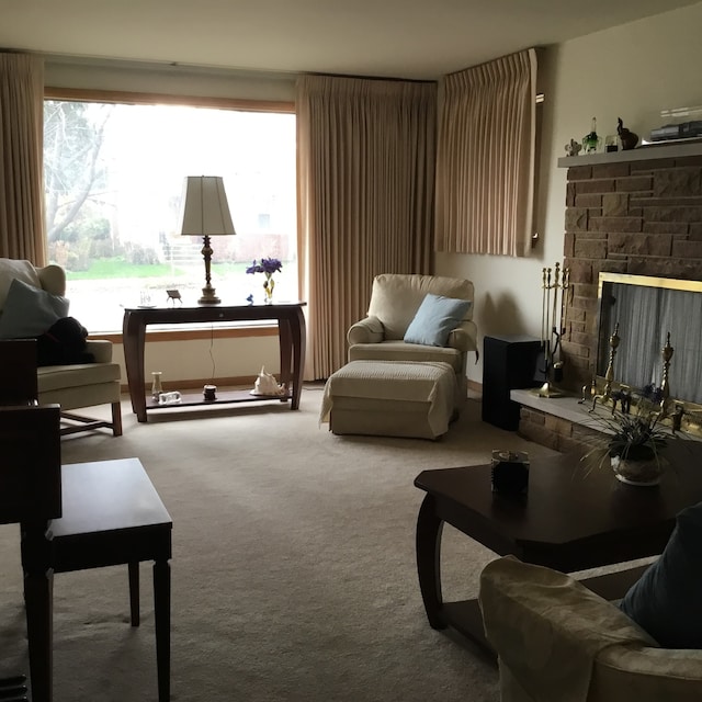 sitting room with carpet flooring and a stone fireplace