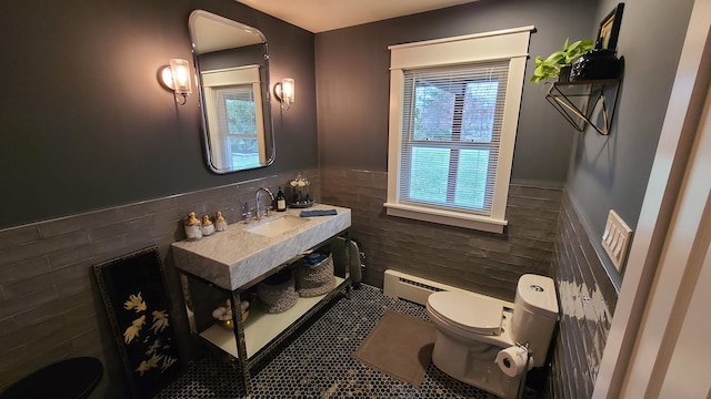 bathroom featuring vanity, baseboard heating, tile walls, tile patterned flooring, and toilet