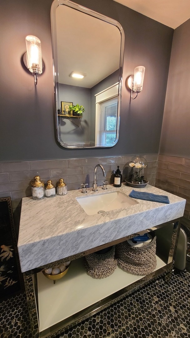 bathroom featuring tile patterned floors, sink, and tile walls