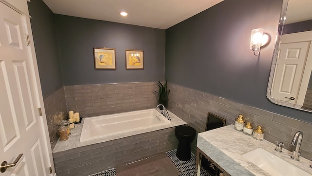 bathroom featuring vanity and a relaxing tiled tub