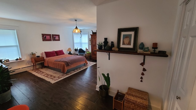 bedroom with dark hardwood / wood-style flooring and baseboard heating