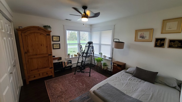 bedroom with a closet, dark hardwood / wood-style floors, and ceiling fan