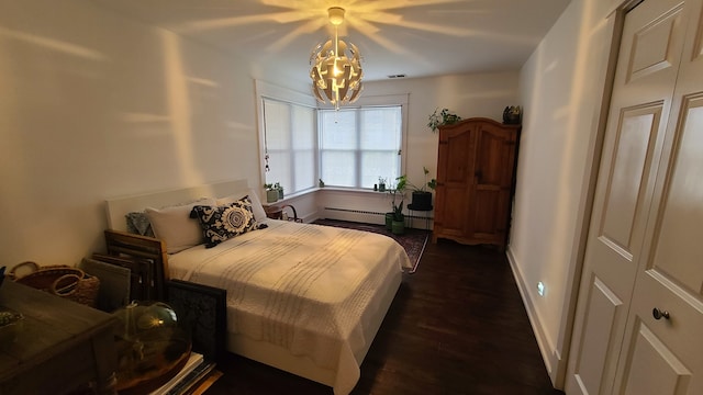 bedroom with dark hardwood / wood-style flooring and a baseboard heating unit