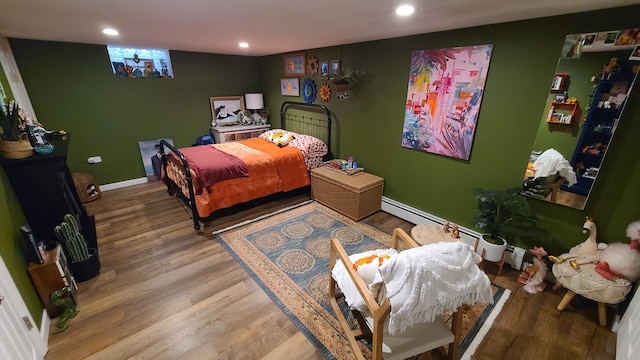 bedroom featuring hardwood / wood-style floors and a baseboard radiator