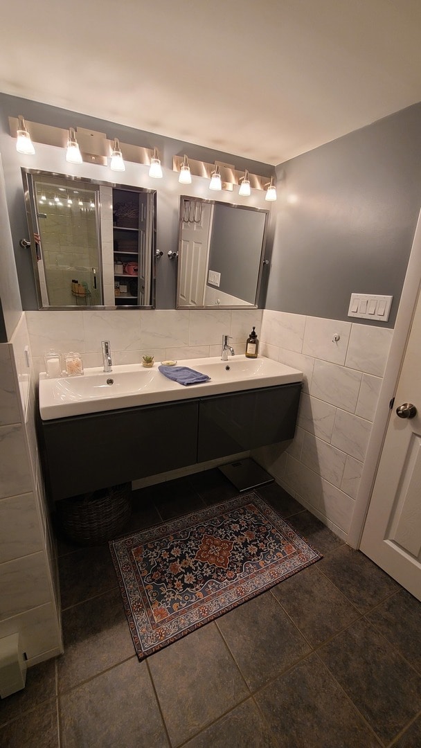 bathroom with tile patterned floors, vanity, and tile walls