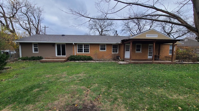 rear view of house featuring a lawn