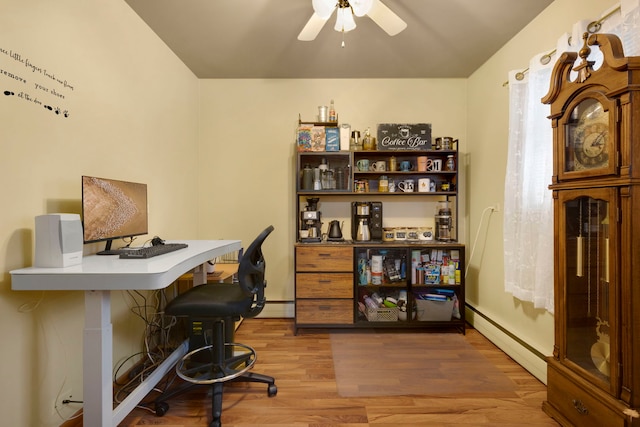 office space featuring wood-type flooring, ceiling fan, and a baseboard heating unit