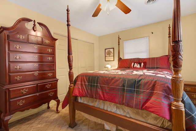 bedroom with ceiling fan, light carpet, and a closet