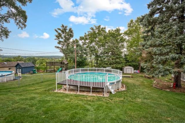 view of pool featuring a lawn and a shed