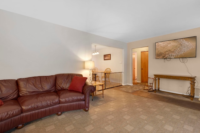 carpeted living room with a chandelier