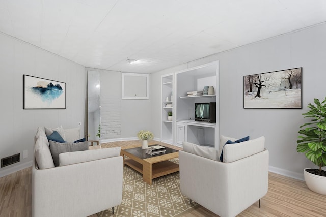 living room with hardwood / wood-style flooring and built in features