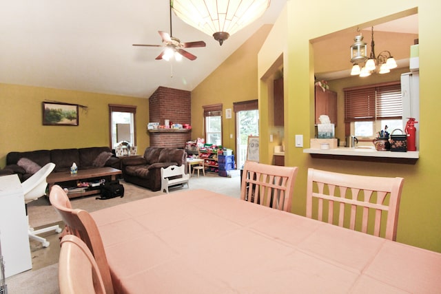 dining space featuring light carpet, plenty of natural light, high vaulted ceiling, and ceiling fan with notable chandelier