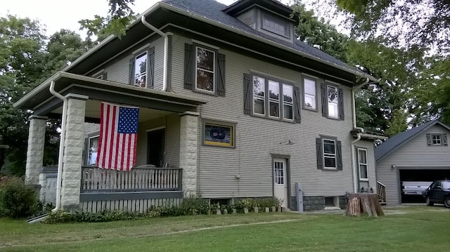 exterior space with a front yard, a garage, and a porch