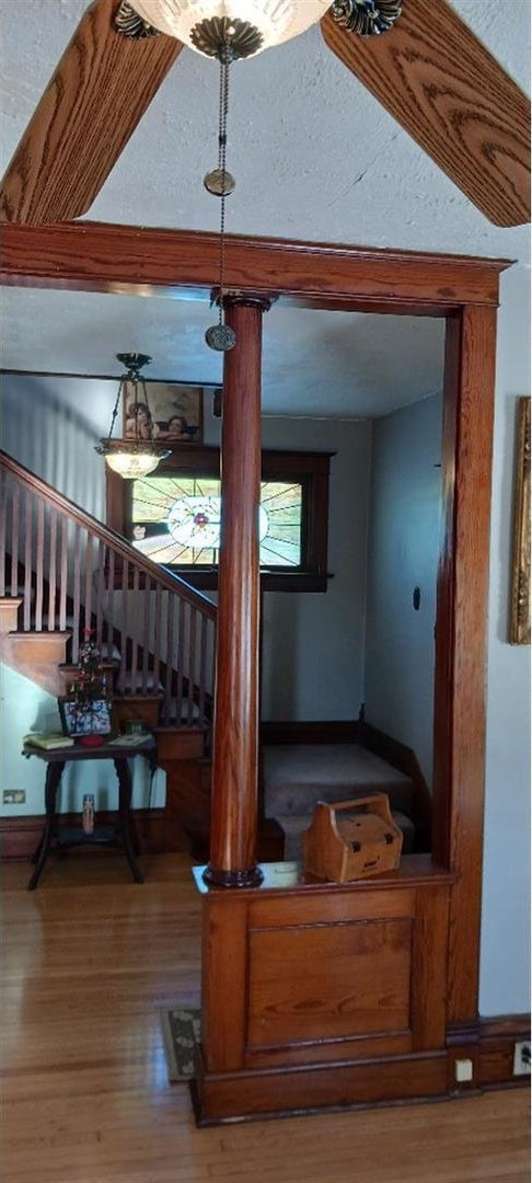 stairway featuring decorative columns and hardwood / wood-style flooring