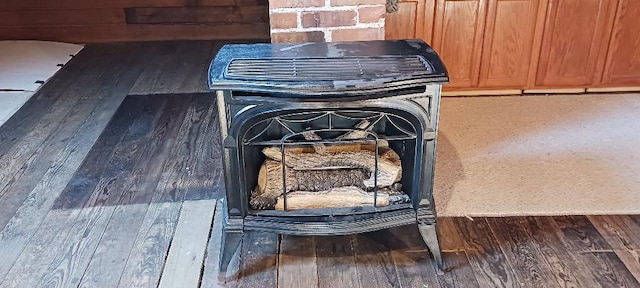 details with a wood stove and hardwood / wood-style flooring