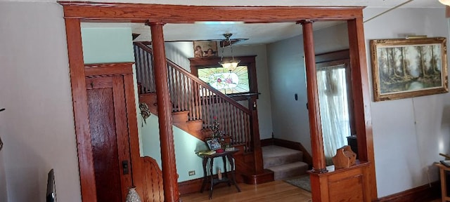 stairs featuring hardwood / wood-style flooring, an inviting chandelier, and a wealth of natural light