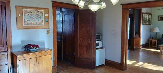 corridor featuring a chandelier and dark hardwood / wood-style floors