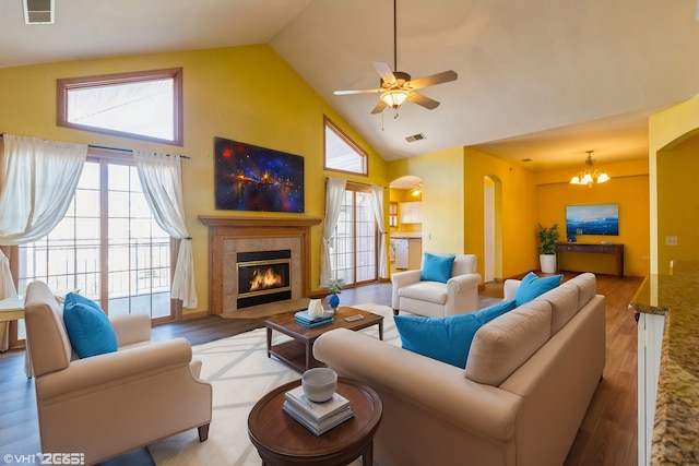 living room with high vaulted ceiling, a healthy amount of sunlight, ceiling fan with notable chandelier, and hardwood / wood-style flooring