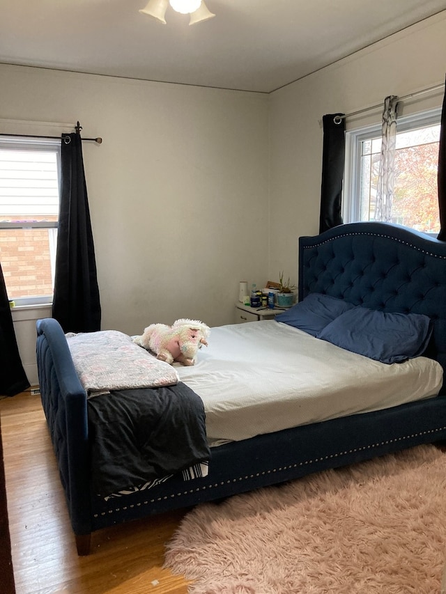 bedroom featuring multiple windows, ceiling fan, and light hardwood / wood-style floors