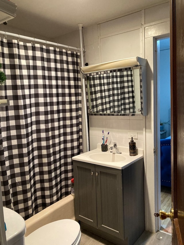 full bathroom featuring wood-type flooring, vanity, toilet, and shower / bath combo