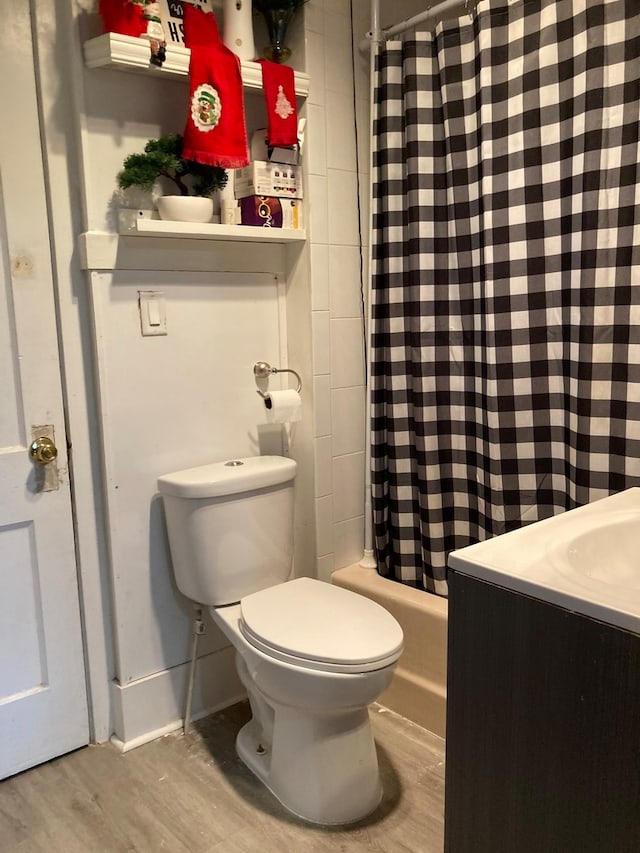 full bathroom with hardwood / wood-style floors, vanity, toilet, and shower / bath combo