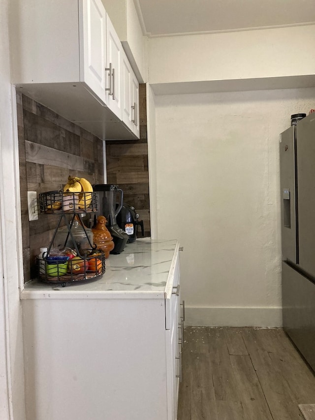 kitchen with white cabinetry, stainless steel fridge, and dark wood-type flooring