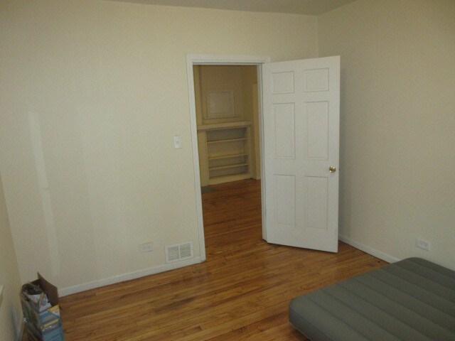 unfurnished bedroom with hardwood / wood-style flooring