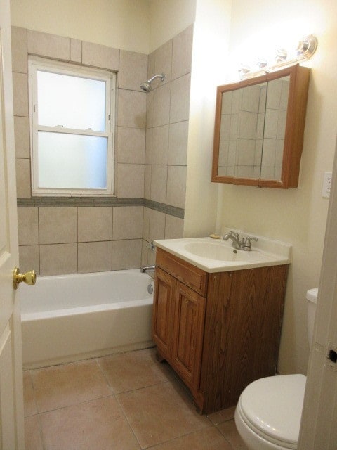 full bathroom featuring toilet, vanity, tiled shower / bath combo, and tile patterned floors