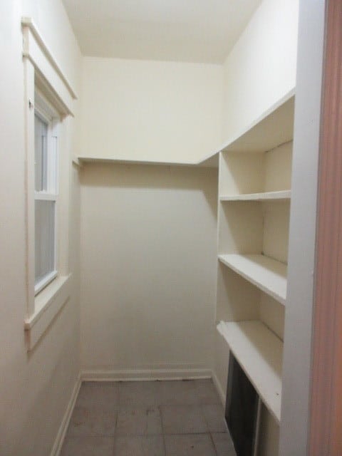 walk in closet featuring dark tile patterned flooring