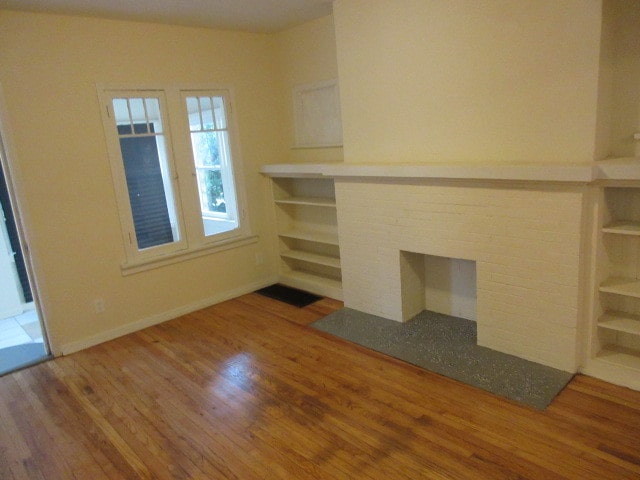 unfurnished living room with hardwood / wood-style floors and a fireplace