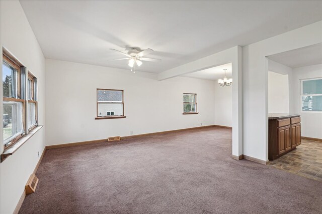 carpeted empty room with ceiling fan with notable chandelier