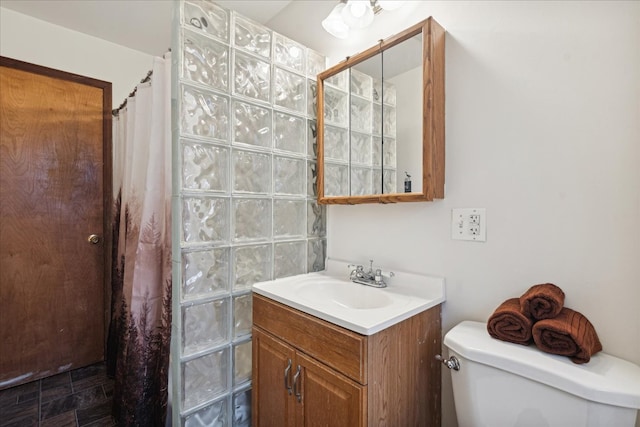 bathroom with curtained shower, vanity, and toilet