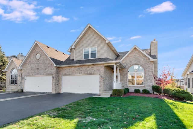 view of property featuring a garage and a front lawn